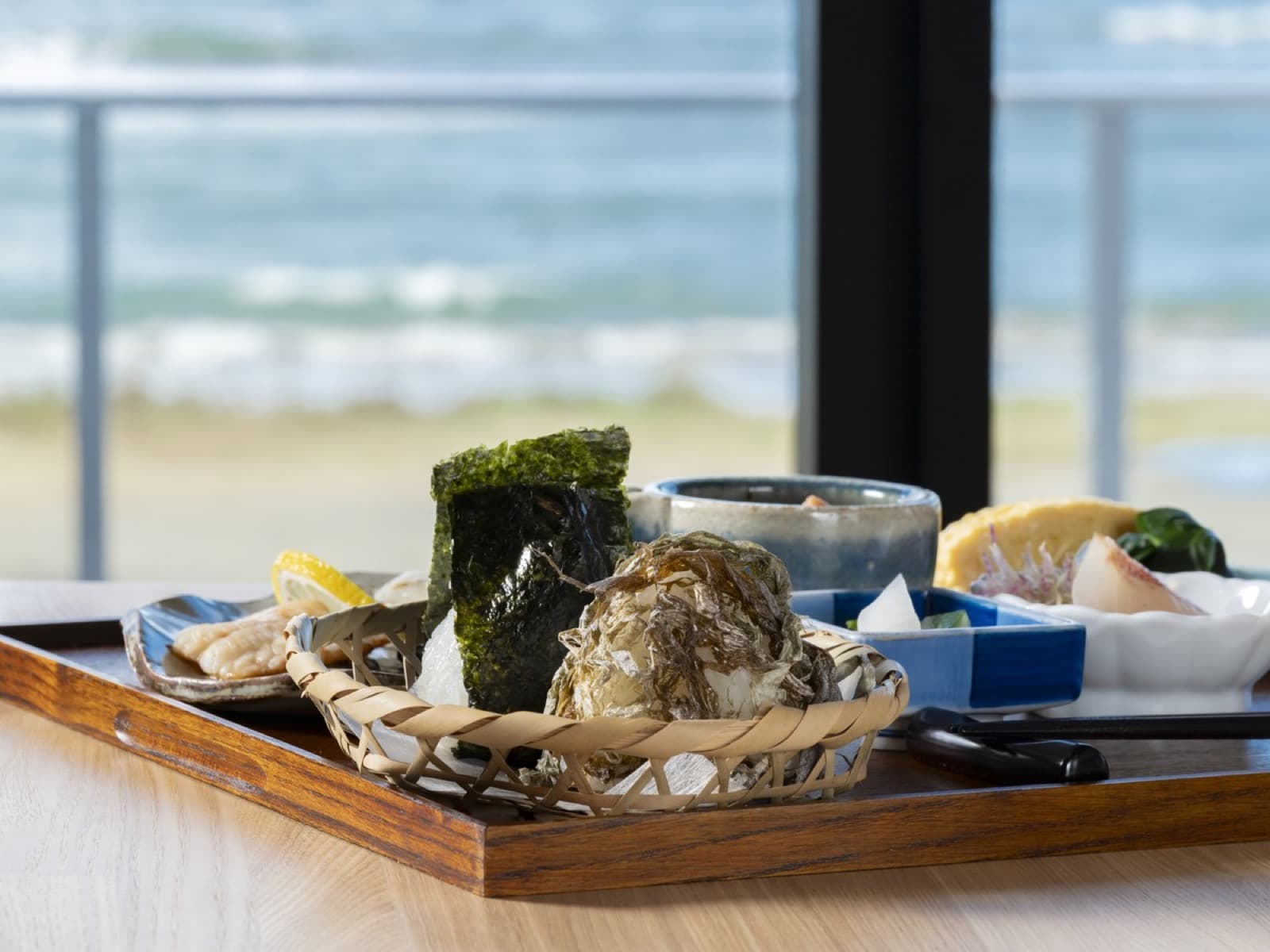 日本海を望む席で味わう和朝食。おにぎりと焼き魚、加賀の小鉢