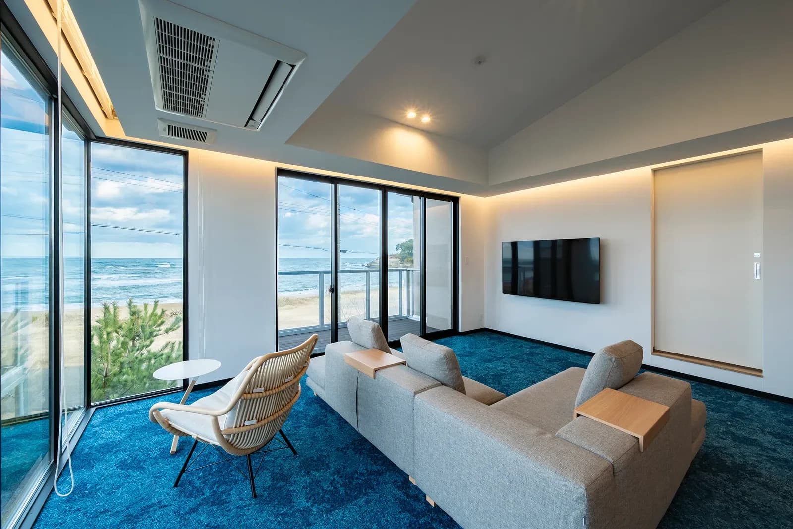 波の間(LUX SUITE)のリビング。角の大窓から日本海を望む
